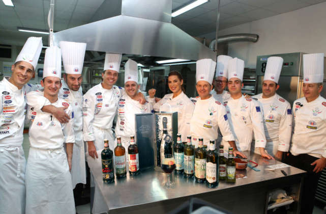Foto di gruppo in cucina degli chef con Veronica Maya e la gamma di Birre Morena